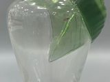 a clear glass vase with a green leaf on it
