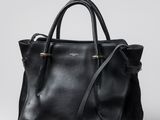 un sac à main noir posé sur une surface blanche