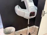 a hair dryer sitting on top of a stand next to a trash can
