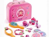 une valise rose contenant une brosse à cheveux rose, un peigne, des ciseaux et d'autres jouets