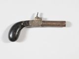 un vieux pistolet avec une poignée en bois sur une surface blanche