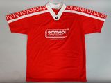 Le t-shirt est rouge et blanc, avec un motif rouge et blanc.