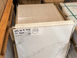 une pile de dalles de marbre blanc dans un entrepôt, posées sur des palettes