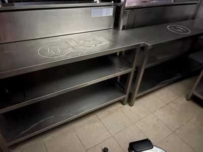 une cuisine équipée de plans de travail et d'étagères en acier inoxydable