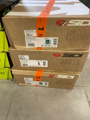 Trois cartons de chaussures sont empilés les uns sur les autres dans un magasin.