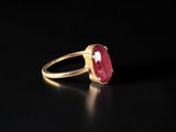 a close up of a gold ring with a ruby stone