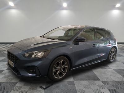 Une Ford Focus bleue est garée sur un sol à damier.