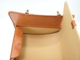 beige and tan leather handbag with handle and strap on a white background