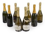 six bottles of champagne are lined up on a white surface