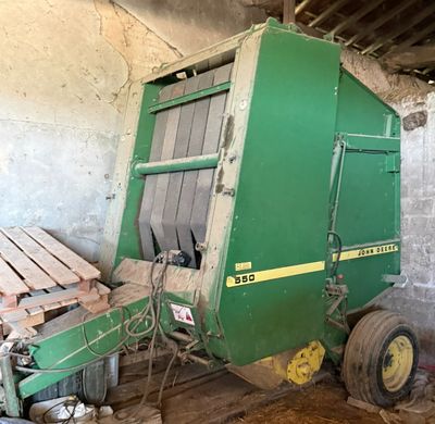 une grosse machine verte garée dans une grange