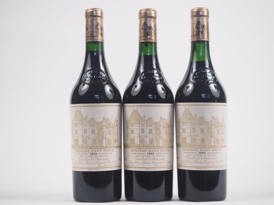 trois bouteilles de vin posées les unes à côté des autres sur une surface blanche