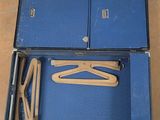 a blue suitcase with a pair of wooden clothes hangers in it
