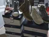several pairs of shoes are stacked on top of boxes in a room