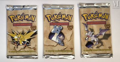 three packs of pokemon trading cards on a white surface