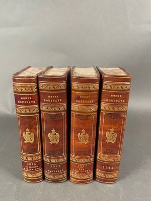 quatre vieux livres sont alignés sur une surface grise