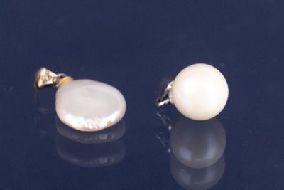 paire de boucles d'oreilles en perles et or sur fond noir avec reflets
