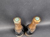 two bottles of wine sitting next to each other on top of a table