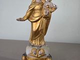 statue d'une femme tenant un enfant dans ses bras, posée sur un socle en marbre