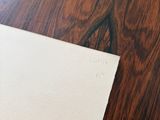 a piece of paper on a wooden table with a pen and pencil