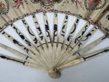 a fan with a design on it sitting on a table