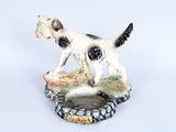 une figurine représentant un chien noir et blanc posée sur une assiette