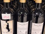 several bottles of wine are lined up on a shelf in a store