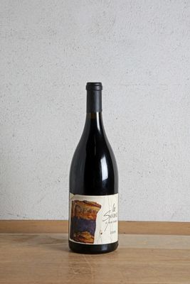 a bottle of wine sitting on a table next to a bottle of wine