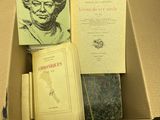 de nombreux livres dans une boîte en carton posée sur une table