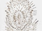 de nombreuses cuillères, disposées en forme de rayons de soleil