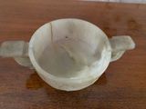a white cup sitting on a wooden table