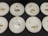 six plates with different designs of fish on them on a black surface