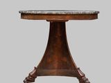 une table ronde avec un plateau en marbre et un piètement en bois