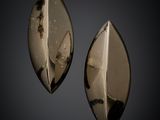 a pair of black and white glass earrings on a black background
