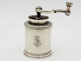 an antique silver coffee grinder on a white background