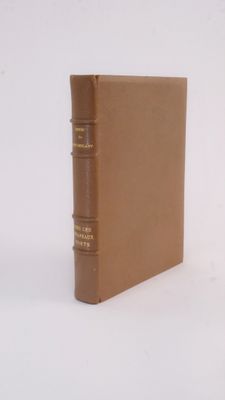 an old book sitting on top of a white surface with a brown cover