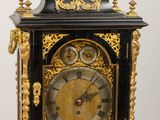 a black and gold clock sitting on a wooden table