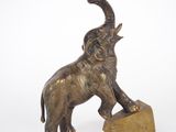 statue of an elephant standing on a block on a white background