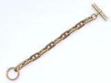 gros plan d'un bracelet en chaîne en or sur fond blanc