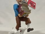 figurine of a man with a stack of books and a dog