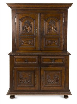 une vieille armoire en bois avec des sculptures et des gravures sur les portes
