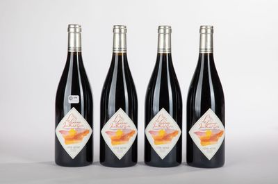 trois bouteilles de vin rouge sont posées côte à côte sur une surface blanche