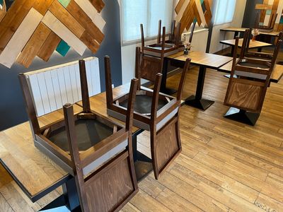 tables and chairs are lined up in a restaurant with wood planks on the walls