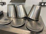 four metal pots on a metal table in a kitchen