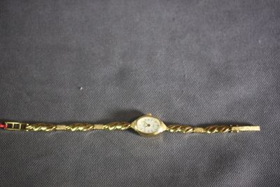 an image of a gold wrist watch with a chain around it