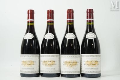 quatre bouteilles de vin sont alignées sur une surface blanche