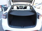 the back of a white car with its trunk open in a parking lot
