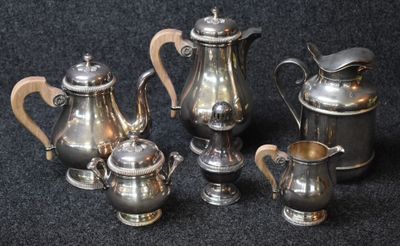 five silver teapots and a coffee pot on a black background