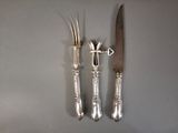 three forks and a knife on a table