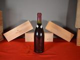a bottle of wine sitting on a table next to boxes of wine