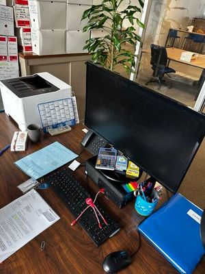 un bureau sur lequel se trouvent un ordinateur, un clavier, une souris et d'autres fournitures de bureau